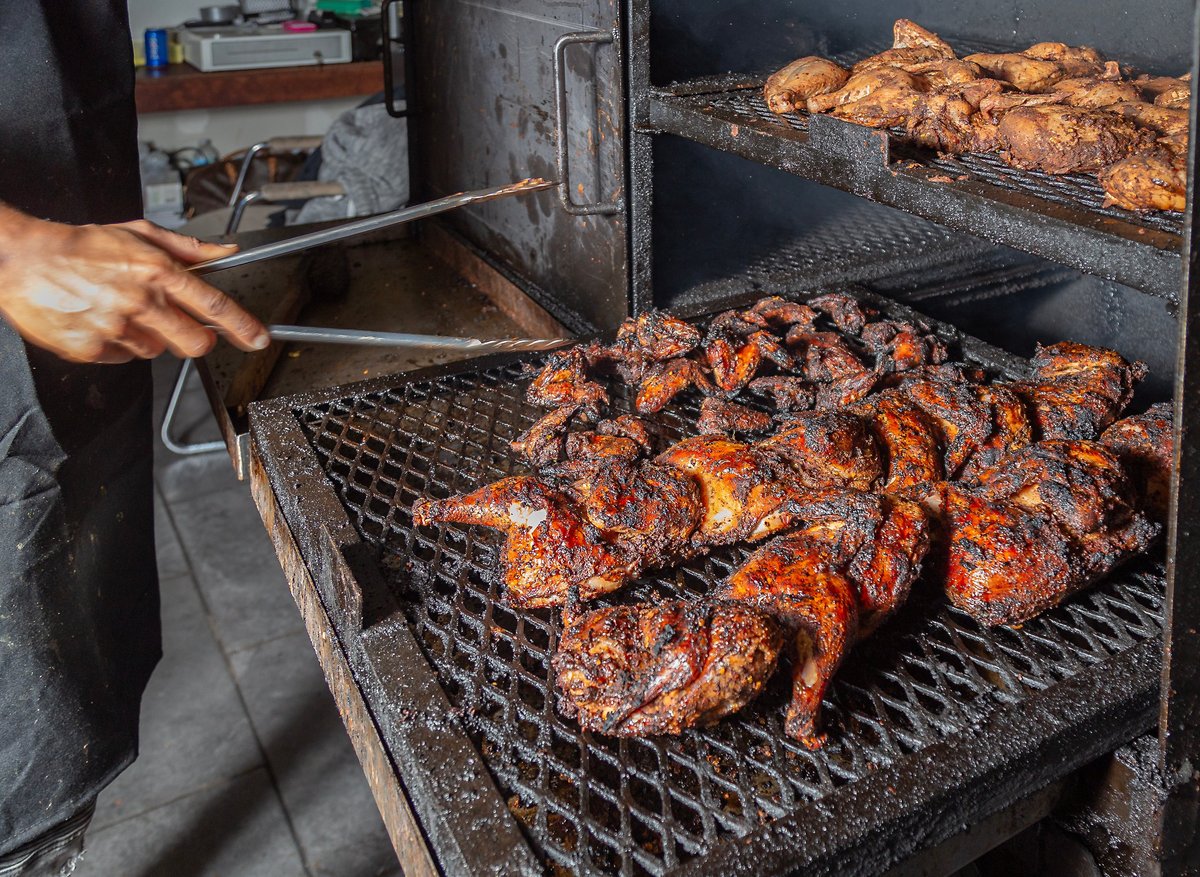 Authentic Jamaican jerk chicken flame grilled over an open charcoal fire